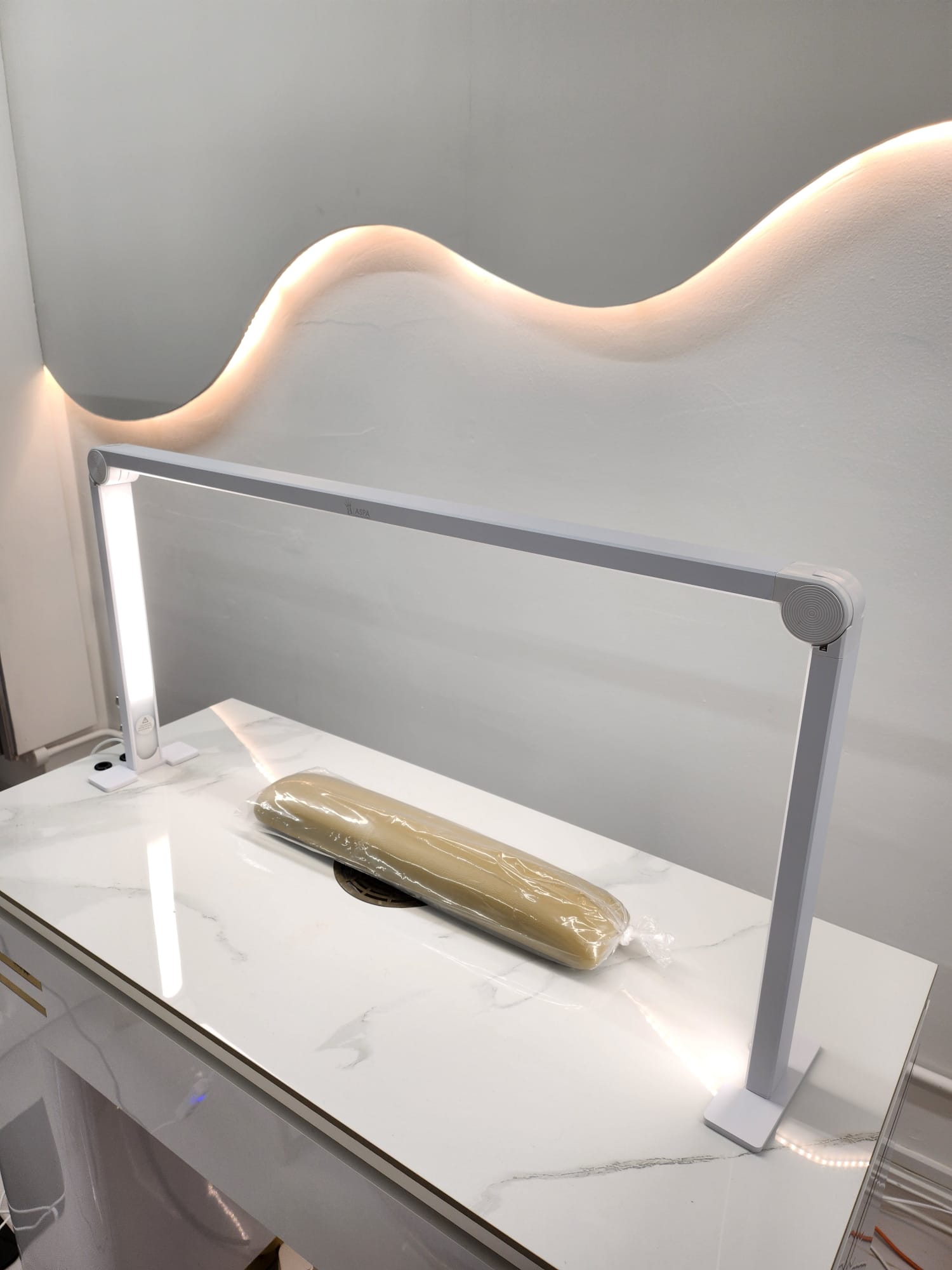 Modern vanity table with a light fixture on a white marble surface.