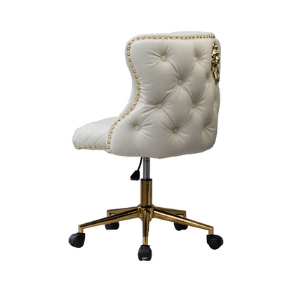 Angled rear view of a white tufted chair with gold nail-head trim, a lion knocker accent, and a gold wheeled base