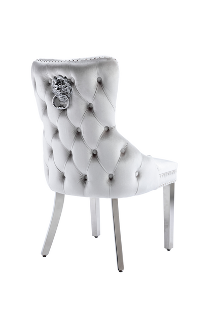 White tufted chair with decorative buttons and a crystal embellishment on a white background