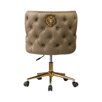 Rear view of a beige upholstered chair with button tufting, a gold lion knocker accent, and a gold wheeled base