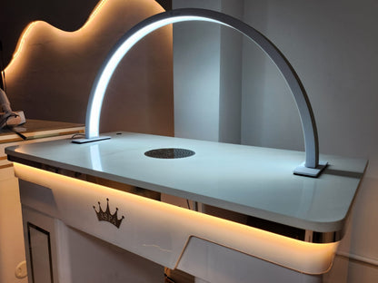 Modern desk with a curved lamp and visible brand logo in a room setting.