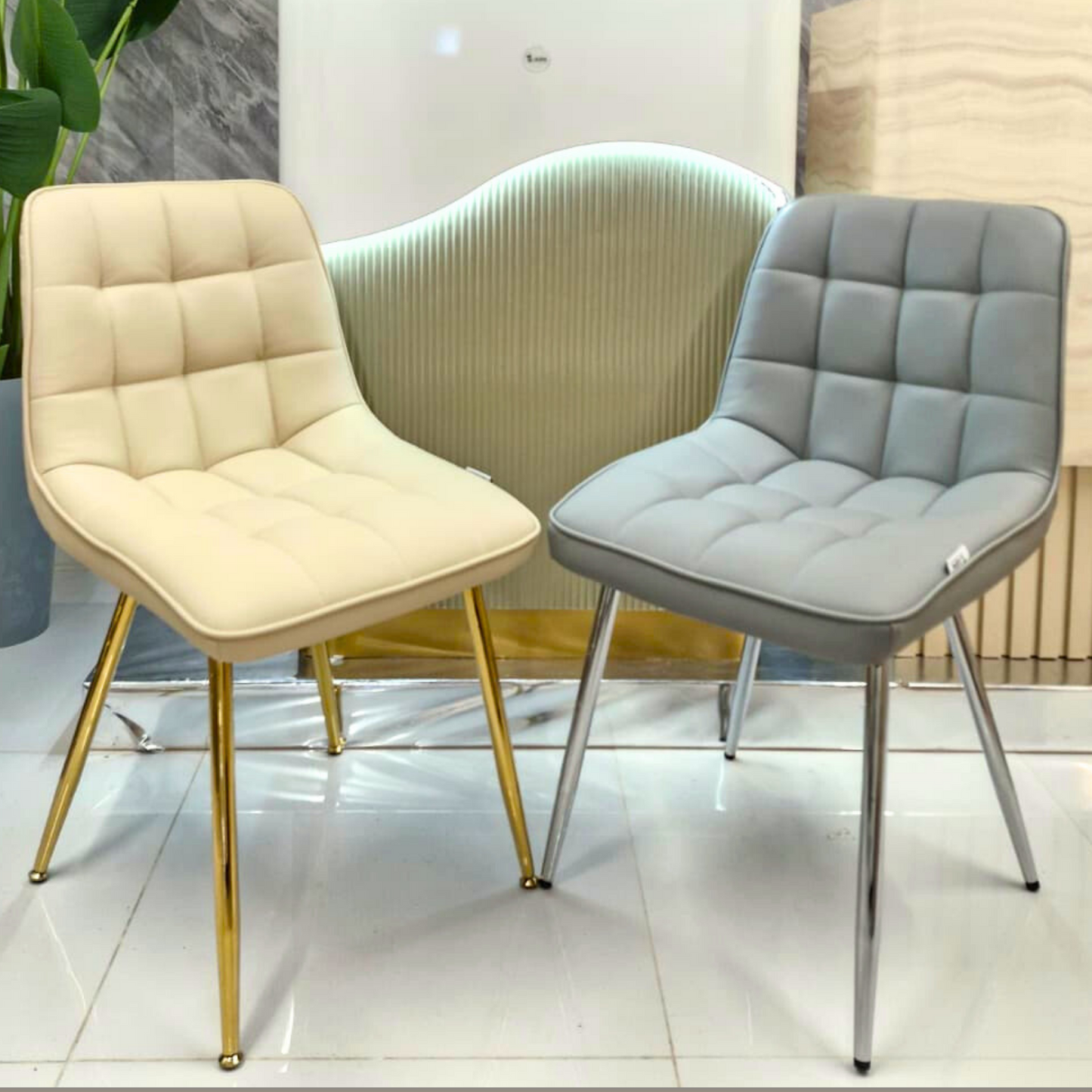 Two chairs, one beige with gold legs and one gray with silver legs, in a modern interior setting.