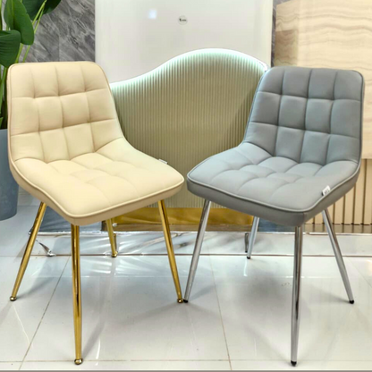 Two chairs, one beige with gold legs and one gray with silver legs, in a modern interior setting.