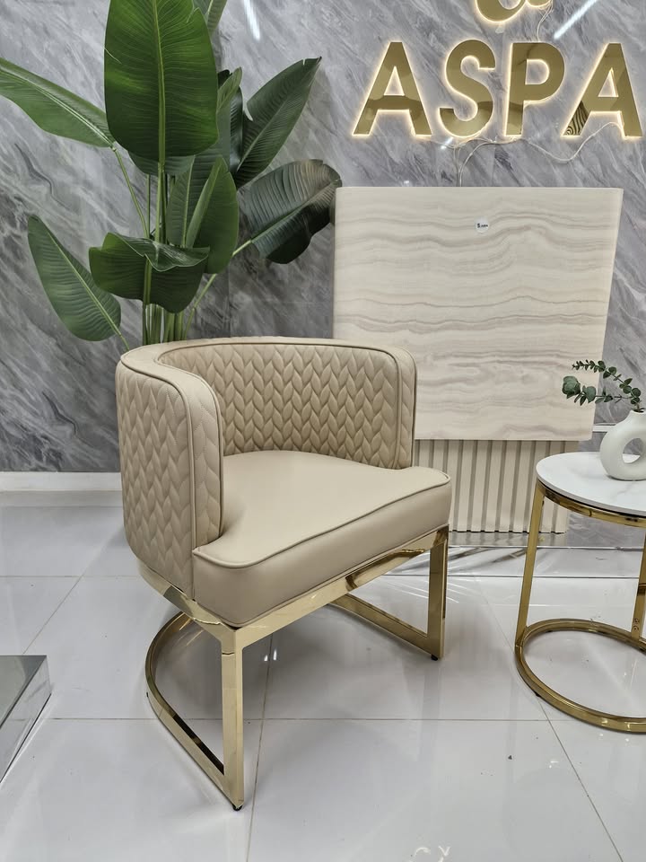 Beige armchair with gold legs in a modern interior setting with 'ASPA' branding.