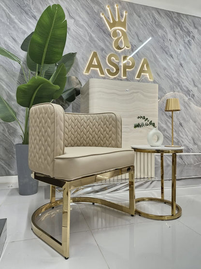 Beige armchair with gold legs in a modern interior setting with 'ASPA' branding.
