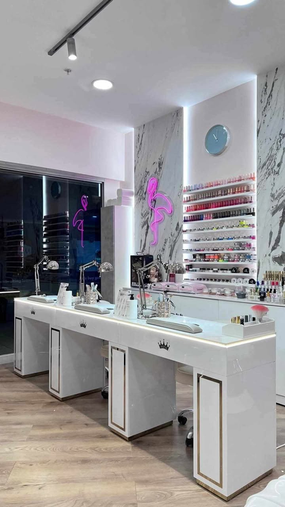 Modern nail salon with white stations and colorful nail polish display.