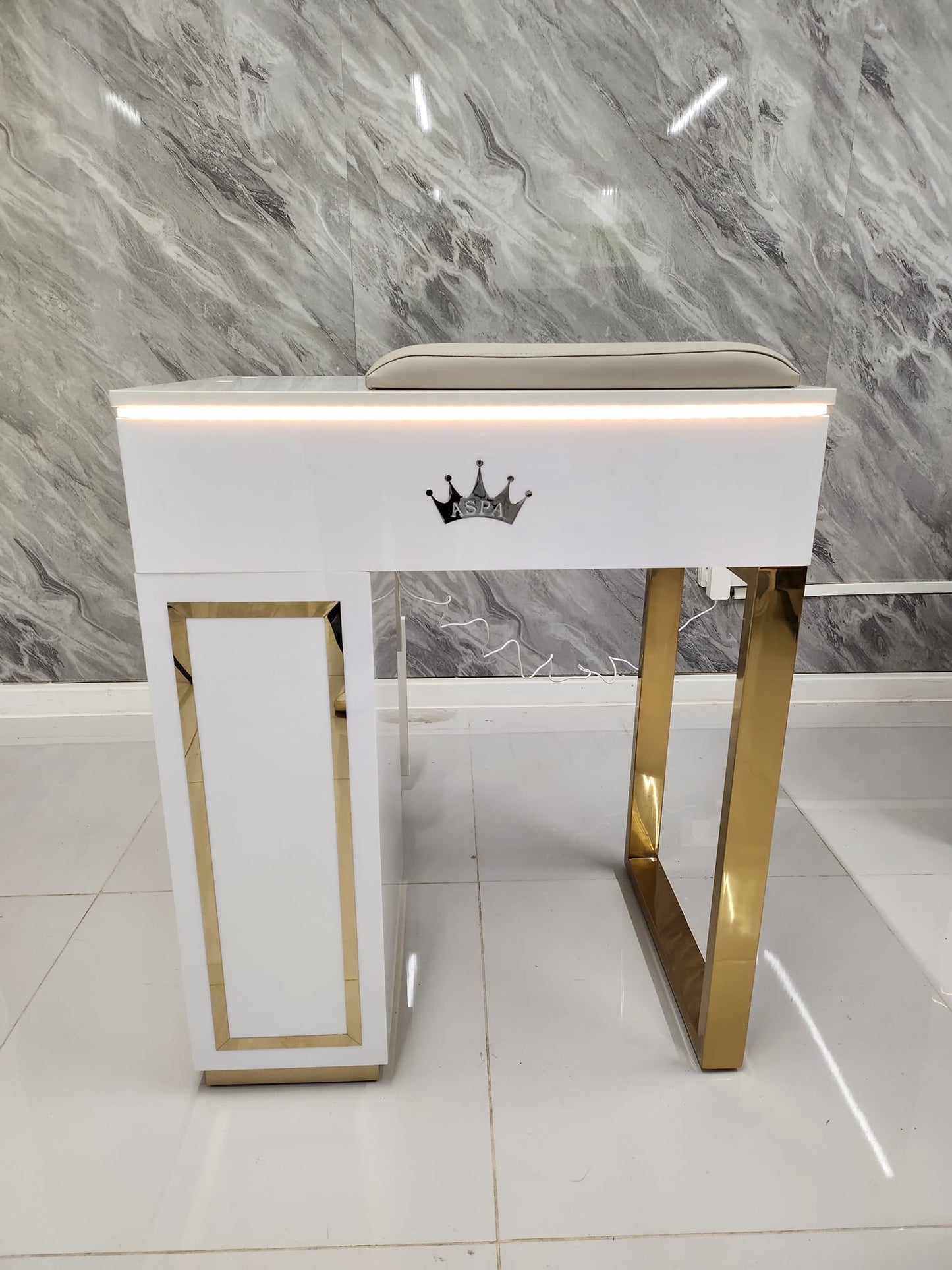 White and gold nail table size 65cm with a crown emblem on a marble background