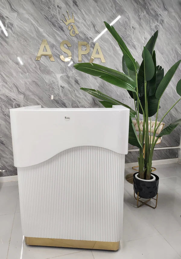 White reception desk with gold accents in a modern office setting, featuring the brand 'ASPA'.