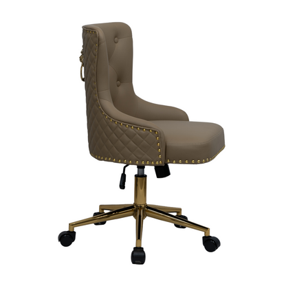 Side view of a taupe upholstered swivel office chair with button-tufted backrest, diamond-quilted side panels, gold nailhead trim along the edges, curved padded arms, and a gold five-star base with castors and height adjustment lever.