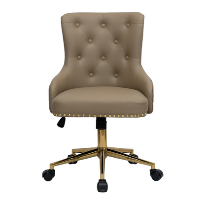 Front view of a taupe upholstered swivel office chair with button-tufted backrest, curved padded arms, gold nailhead trim along the seat edge, and a gold five-star base with castors and height adjustment lever.