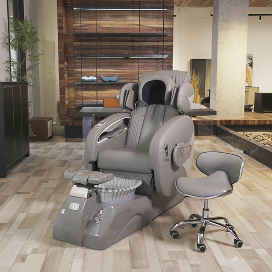 A grey pedicure chair with a full body massage system, equipped with a high-quality basin, jet system, LED light, drain pump, and a spray hose, positioned in a salon setting.