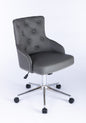 Three-quarter front view of a grey upholstered swivel office chair with button-tufted backrest, curved padded arms, nailhead trim around the seat edge, quilted side panels, and a chrome five-star base with castors and height adjustment lever.